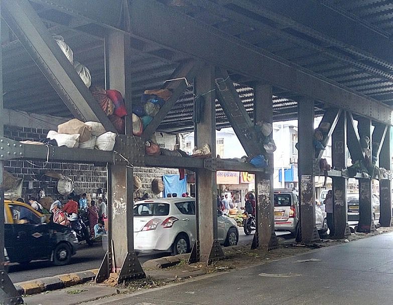 Hawkers use the columns of the Tilak bridge as their storage 